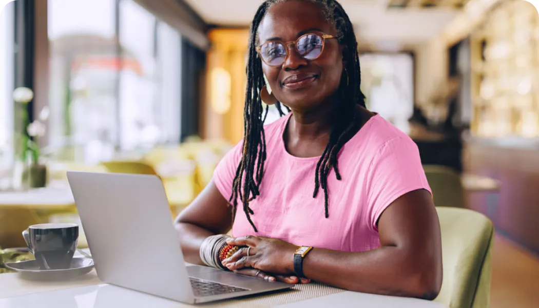 healthcare student smiling while doing coursework on her laptop computer